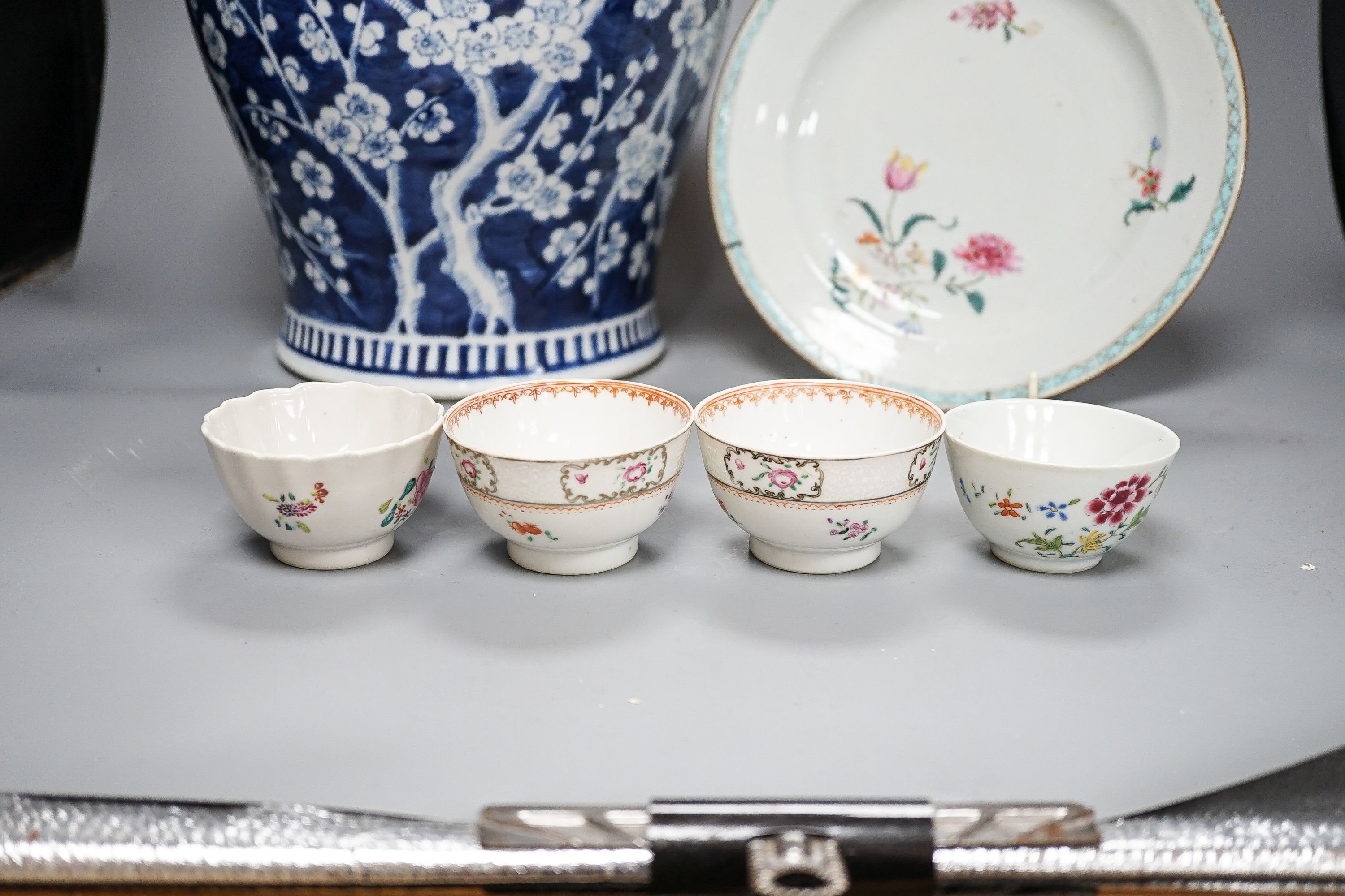 A 19th century Chinese blue and white Prunus jar and cover, 36cm and a group of 18th century Chinese export famille rose tea bowls and a plate